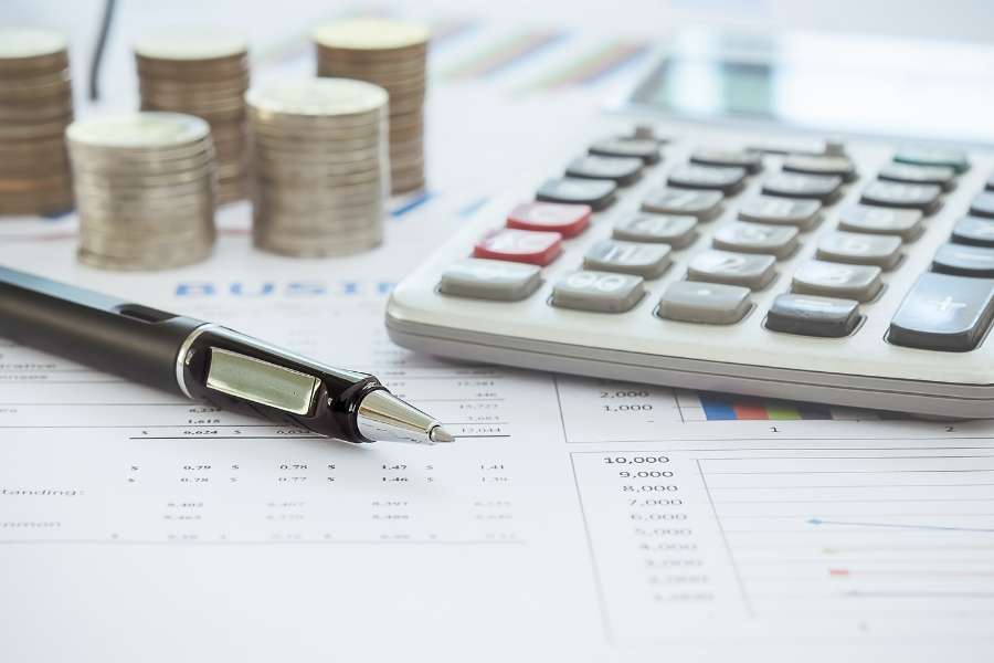 Calculatrice et pièces de monnaie sur des documents financiers pour augmenter la valeur de votre appartement.