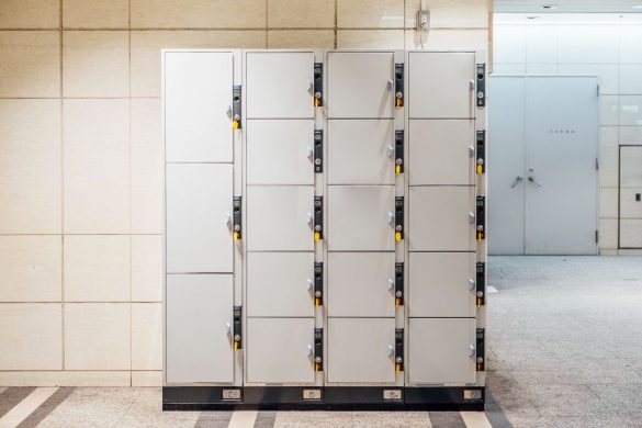 Grande structure de casiers métalliques gris sécurisés dans un hall, idéale pour s'inspirer du rangement modulable d'une armoire à fusils.